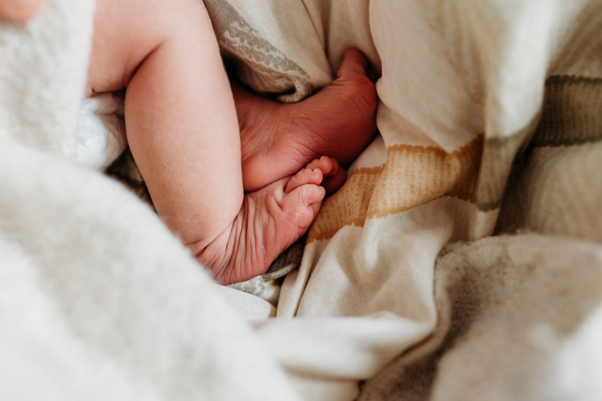 Faltige Füße eines Neugeborenen - natürliche Babyfotos Landshut Münche