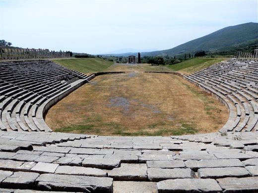 The Stadium is a prestigious building complex. It has a horseshoe shape, with ramps and stairwells, seats for the prominent citizens.  At the bottom there is a Roman addition of protective walls as in those years it was turned into an arena. The northern horseshoe section of the Stadium includes 18 stands with 18 rows of seats, separated by staircases.  It is surrounded by Doric arcades, whose columns are mostly in place. The northern arcade is double, the eastern and the western are simple.