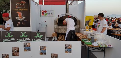 One of the 50 pizzaioli baking pizza in real wood-fired oven, in 8th Napoli PIzza Village.