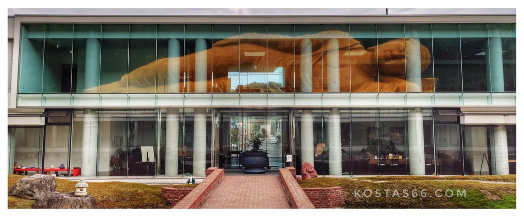 The reflection of the golden statue on the glass façade of the building standing just oppose it.