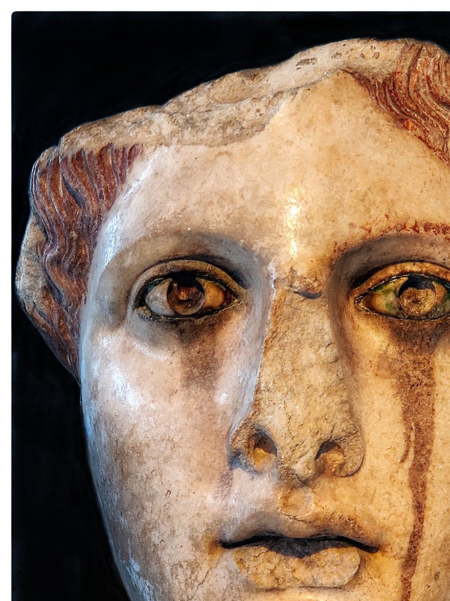 Head of female statue.  A marble copy of a gold-and ivory statue of the classical period (5th-4th cent BC). It represents a goddess, perhaps Aphrodite. The color that has leaked below her eyes is a product of the oxidation of the statue's bronze eyelashes.
