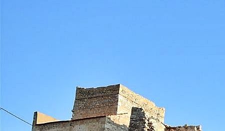 The ruins of pirate’s Nikolos Sassaris tower-house seen from the small pebbly Kato Mezapos beach.