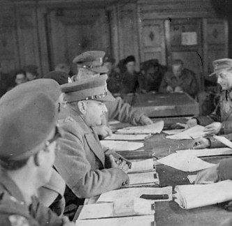 V.l.n.r.: chef-staf brigadier George Kitching, generaal Ch. Foulkes en tolk kapitein G. Molnar en aan overzijde: tolk majoor Olderhausen, generaal Blaskowitz en chef-staf generaal Paul Reichelt