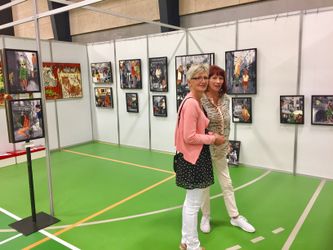 Hanne Aabo viser sine spektakulære billeder, med en blanding af foto og maleri til en gæst.