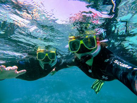 Dos personas practicando snorkeling en un día soleado.
