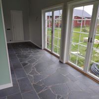 "Serenity Haven: Relaxrum med Skiffergolv och Fönster till Naturen"