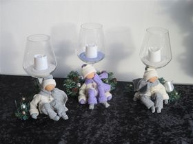 Winterfiguurtjes op een glaskaarshouder