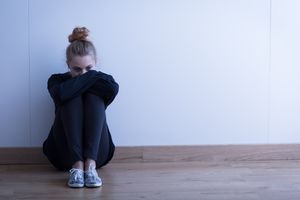 aengstliche-schuelerin-sitzt-am-boden