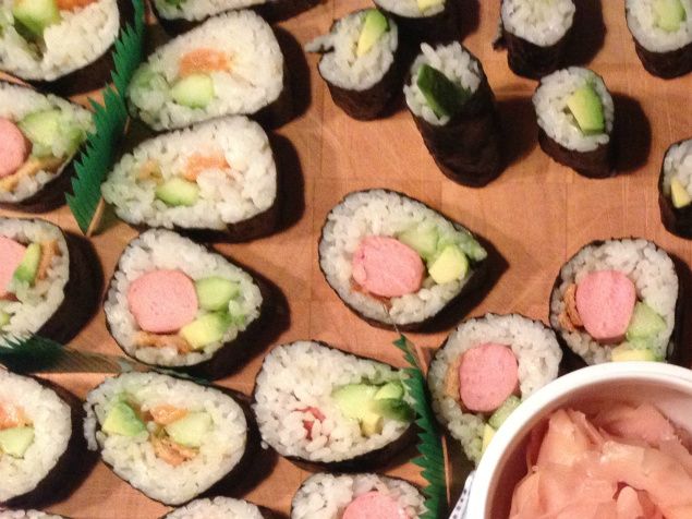 500 g. sushiris koges i 750 ml. vand. Når risene er færdige, kommes 1 dl. risvin-eddike i og risene køles i ca. 30 min.
Mens risene køles, skæres tilbehøret til rullerne. Tag en hel agurk og skræl den. Del den på langs og tag gernerne ud. Del den halve agurk i 4 dele på langs. Tag 2 avocadoer og tag stenen ud. Afmonter skrællen og skær kødet i lange stykker. Kødfyld er ofte en personlig sag og i dette tilfælde er der lagt vægt på familiens ønsker. Rå laks fra fiskehandleren i Torvehallerne, Kogte rejer, kyllingepølser og friturestegt tofu (kan købes på dåse hos asiatiske købmænd). Kødet skæres i længder, som passer bedst til rullerne.
Nu tages et stykke Nori-tang, som lægges på en sushi-måtte. Plast-måtterne er klart at foretrække. Risen tages ud af køleskabet og nu kommer tricket. Stil en lille skål med vand ved siden af risene og dyp fingerspidserne. Umiddelbart efter tages risene over på tangpladen og bredes ud over det meste af tanget. Der skal ikke ris på de øverste 1,5 cm. af tanget. Pas på med at komme et for tykt lag ris på. Nu kommes fyldet ovenpå risene ca. 2-3 cm. fra endestykket mod én selv. Når der er kommet det valgte fyld på (og evt. wasabi pasta), skal tangpakken rulles. Når den næsten er rullet sammen, dyppes en finger med vandet i skålen og den sidste 1,5 cm fugtes. Det gør, at rullen 