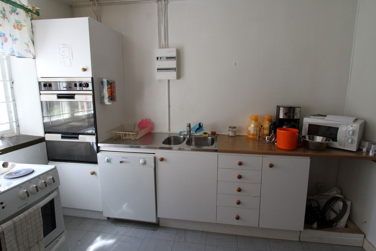 Köket med diskbänk, ugn och mikro.