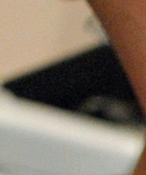Man lyfter med en hand kettlebelt och har svarta skor på sig