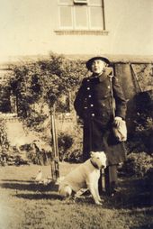 M55 Mrs J Newbould WVS, with dog, in garden of her house, No.2 Cloonmo