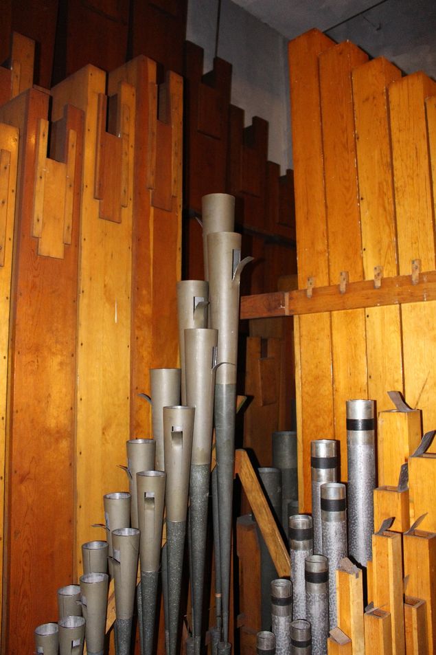 (con't from Part VII)
[Photo:  courtesy of Kimball organ at Saint Louis Scottish Rite Cathedral in Saint Louis, Missouri; taken 15 feet in the air in Main chamber facing northwest corner, pipes of Harmonic Trumpet (center, metal), English Diapason (right, metal), Concert Flute (Pedal Bourdon, wood, right), Principal Diapason (wood, left), Pedal Contra Bombarde & Clarion (wood & metal, background)] 
Organists often complain about tuning; the pipe organ is a wind instrument, and it's affected by temperature and humidity (See blog, Temperaments & Tuning, Part VII).
When it's warm the organ will go sharp; when it's cold it will go flat; normally this is not particularly noticeable, except that the reeds are NOT much affected by temperature; their pitch is determined by the length of the brass tongue that vibrates.
If the whole organ was tuned in winter at 68 degrees Fahrenheit, in the summer heat the flues will go sharp and leave the reeds behind, sounding flat to everything else.
In some voicing styles, notably by Schantz, reed pipe pitch is determined as it is with flue pipes, by the length of the pipe; in others, such as used by Fisk, it's determined entirely by the length of the tongue.
It's important to understand this when tuning reeds.
Schantz reeds, for example, are almost all tuned with a scroll at the top of each resonator (as in photo, which shows a Kimball Harmonic Trumpet); Fisk reeds, on the other hand, have no scrolls -- most are 