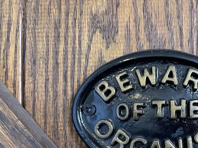 The humor in this door sign (photo) derives from the fact that keeping one's distance from certain things is actually a warning to organists, not their visitors.
We allude here to such concerns as distractions.
The subconscious mind is the seat of memory, and it will function automatically for us in a performance situation if fear is taken out of the way.
It's important therefore for us to focus down on what's happening in the current measure of music as we play, concentrate, and NOT let things distract us -- like a sudden, unexpected, enormously loud and startling burst of patriotic applause -- like maybe some tricky place up ahead -- like some earlier mistakes we had to correct or one that crops up unexpectedly -- like someone asking us questions -- like someone wanting to shake hands with us --  like someone wanting us to look into their camera and smile while we're trying to sight read from the page (yes, they do that to us, too).
All of these things can trip us up by hijacking our eyes, ears, hands, mind, and/or attention; while we're smoothly cruising along in a performance situation these kinds of things can suddenly grab our focus, our concentration, by the scruff of the neck and rudely strip it away for a moment, leaving nothing behind but our motor memory and the task of recovering our bearings.
No tension -- no play -- but relaxation needs to be blended in so that it's about a 50:50 mix of tension and relaxation -- what amounts to getting in the middle of the road and never all of one thing; in that sense, being able to balance one against the other at any point along the way makes organ playing very athletic.
What many of our well-meaning non-musician friends and listeners don't always seem to realize is that a stream of inspired sound doesn't simply emerge from the instrument by some automatic process as soon as organists seat themselves at the bench and start playing; the musician's total attention, mind, memory, and focus are needed to where, with the possible exception of receiving a smile and a nod of the head, it's impossible to hold any semblance of meaningful communication with them at the same time.
From a purely mechanical standpoint there are no issues (save for physical limitations) which repetition, having the right tools, and adopting the habit of fiercely concentrating cannot solve.
To be alert enough to concentrate requires us to guard our health and get enough rest; here again, it's all about balance.
Everything in organ playing is balance [See blog, Balance In Organ Playing, Parts I-III].
When we play, if we make a little mistake, we don't dwell upon it -- we just leave it behind and keep moving forward ... it's in the past.
If we begin to start thinking about why we just made the mistake then pretty soon we're making a few more because we're getting distracted and not staying with the moment.
It can be aggravating when we know we can play it better and have done so countless times -- interference can enter the mind from any direction -- but we just need to chalk it up, forget about it, and keep moving, just like we would when we're sight reading.
The more we can cultivate the habit of NOT getting provoked with ourselves if a little blemish happens in our playing, the better our memory will function through the remainder of the music.
Some of the best advice we can receive is to let go of that perfection thing ... to forget about playing it 
