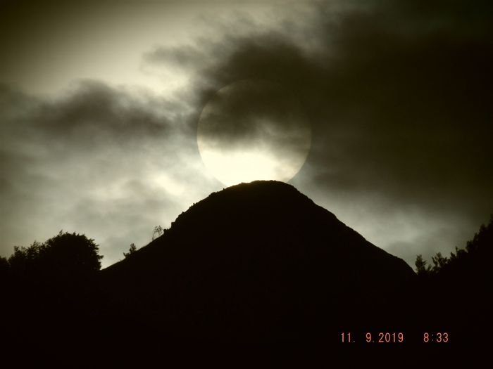 Page 2 de cet album photo, j'avais mis une photo du 10 à gauche et une photo du 12 à droite, mais il manquait celle du 11 pile juste au sommet que voici. En effet, pour prendre le Soleil en face et voir nettement son contour et le paysage autour, il faut quelques nuages fins devant. Cette année, j'ai donc pu prendre le lever de soleil le 11 septembre sur la pyramide naturelle visible sur beaucoup de photos de cet album, et comme vous pouvez le constater, il se lève pile juste sur la pyramide le 11.