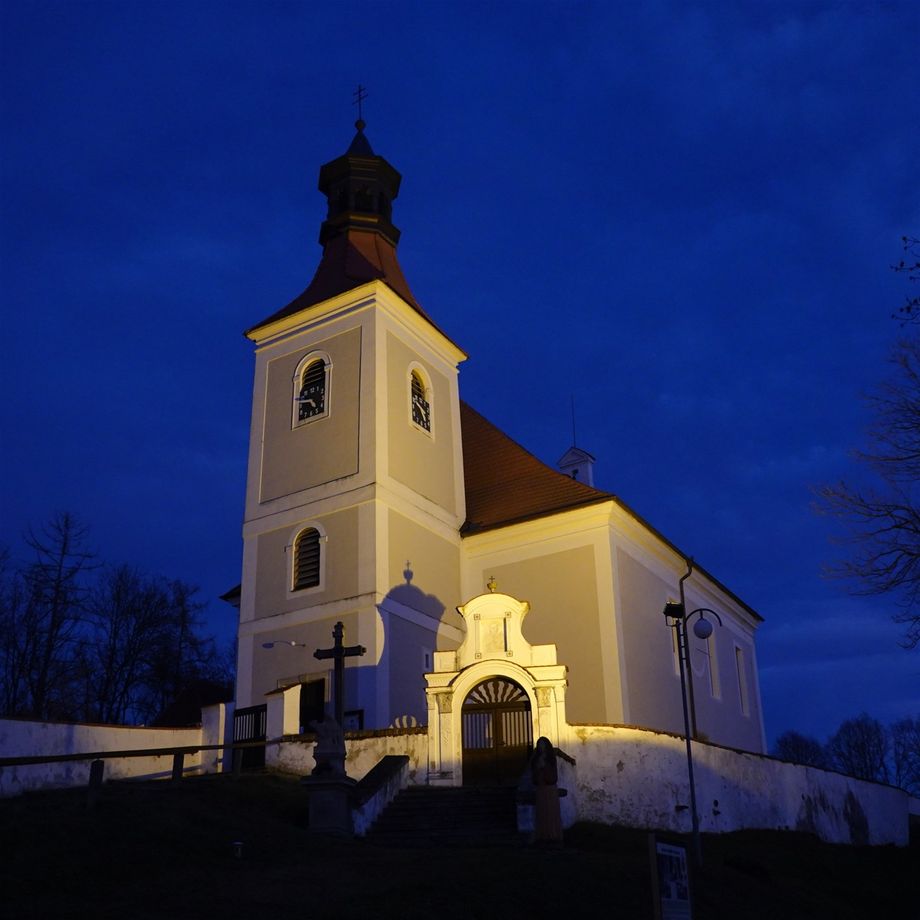 31.12.2021 Kostel svatého Vincence stojí na vysoké ostrožně nad dávným brodem přes řeku Malši, v místě slovanského hradiště z 9.století. Krásná Madona doudlebská, uctívaný obraz z 15. století, má dnes svoje teplé místo v Národní galerii v Praze. V zamčeném opevněném kostele na barokním oltáři mrzne jedna z jejích kopií. Je poslední den v roce, tichý soumrak brzy proříznou světlice a ohňostroje. GPS 48.8932842N, 14.5053844E