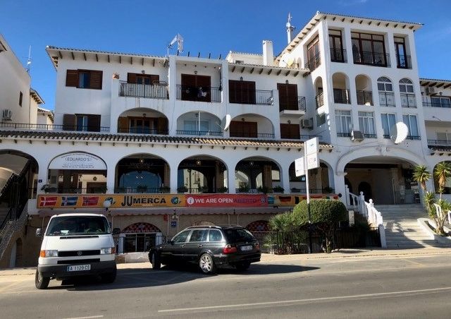 Knappt 10 minuters promenad från lägenheten ligger Villamartín Plaza. Här finns ca 20-25 restauranger i tre plan med varierande utbud. Finns det barn med i sällskapet föreslår jag en av restaurangerna en halv trappa ner. Här kan barnen springa helt fritt på torget medan föräldrarna äter färdigt i lugn och ro. Här finns flera mindre butiker, mäklarföretag och en bank med bankomat, Caixa Bank. I souterrängplan utmed gatan, ligger en mindre livsmedels-butik som har det mesta. Manuell chark, frukt o grönt, mejeriprodukter, kemisk-tekniska produkter och givetvisl vin, öl och även starkare drycker för de som önskar köpa sådant. Under högsäsong är butiken öppen alla dagar i veckan med mycket generösa öppettider. Entrén är rakt under 