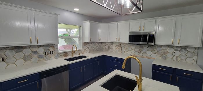 Total kitchen remodel. Painted cabinets w/new hardware, tile backsplash, quartz countertops, new plumbing fixtures, new flooring, new paint.