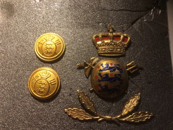 hattmärke i tre delar med knappar. Tullen Danmark