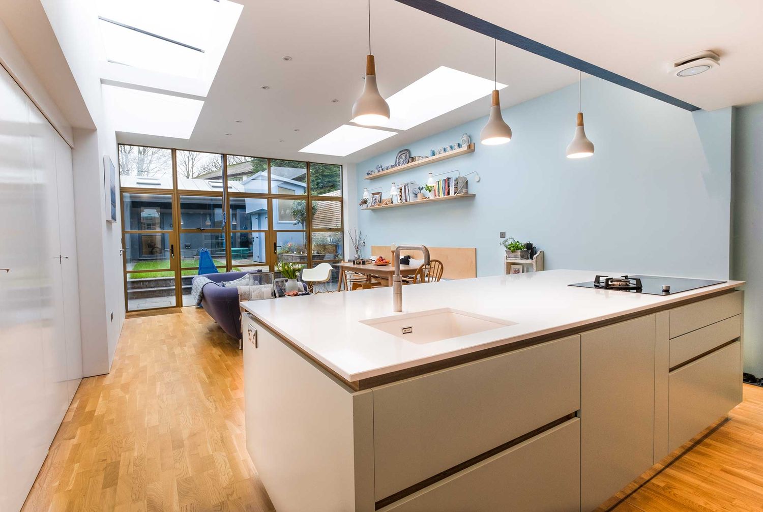 Bright open-plan kitchen extension with a white island and rooflights