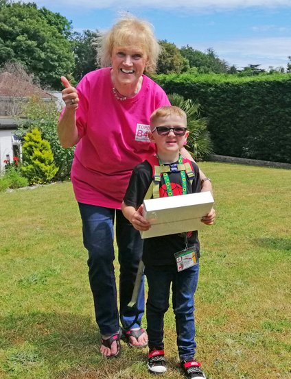 Sue giving a laptop to a disabled child Sue giving a laptop to a disabled child