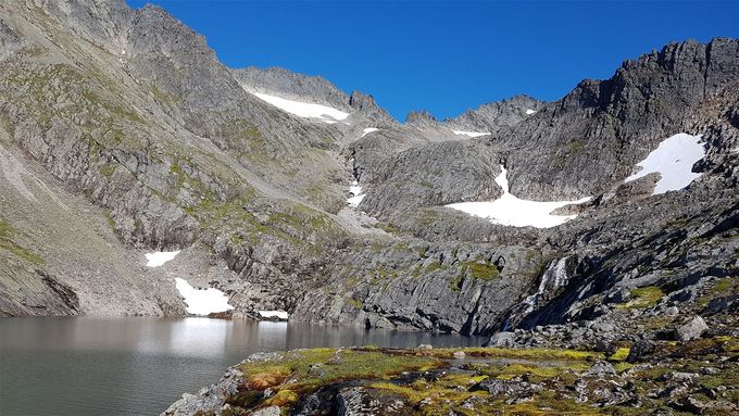 4. vannet som passeres på høyre side. Her er sti høyt over vannet. I bakgrunnen ser en Blåbretind og Skarrabben. Der en ser en snørenne midt i bildet  er veien videre opp mot skaret på venstre siden av rennen