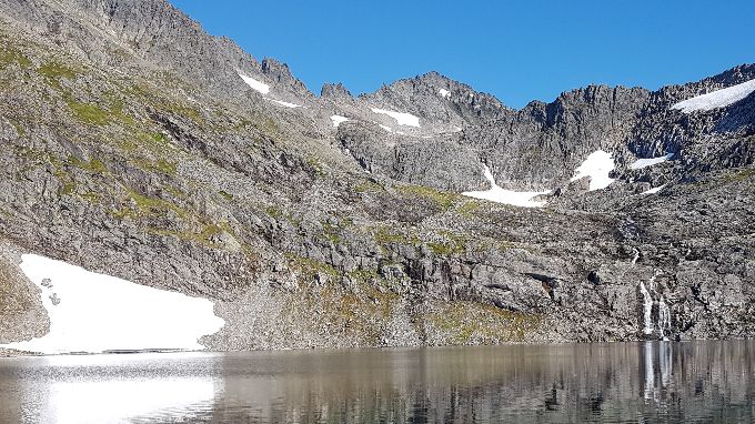 Ved 3. vatnet. Turen går videre til høyre side av vannet. Området før elva (som kommer ned fra 4. vatnet) er ofte dekt med snø til langt ut på sommeren, da kan det være vanskelig å komme seg bort mot elva hvor en videre går opp (der er det festet bolter for tau)