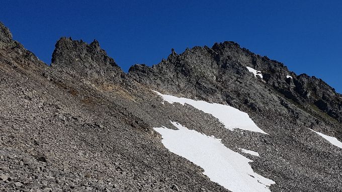 Her kan en kanskje se det bedre . Der er den første tydelige renne med vegetasjon  en må gå opp. Den ser en nesten peker opp høyste del av fjellet