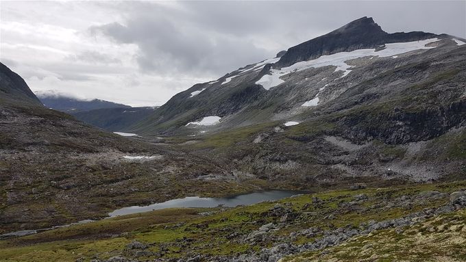 På vei opp og utsikt ned mot Russadalsvatnet (langt ned i dalen) med Skruven til høyre. Det er helt i andre enden av fjellryggen at en går opp på Skruven
