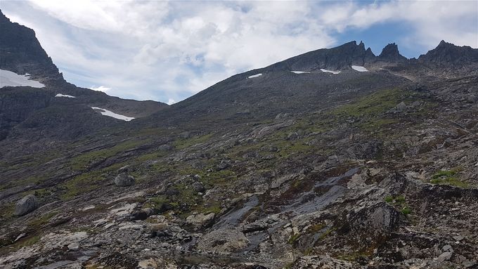 Toppen av Stokkfonntind sees litt mot høyre. Her ser en lia som en må skrå oppover for å komme frem. Deretter må en gå mot ryggen mot toppen omtrent midt på bildet