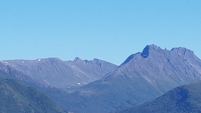 Hammarsettinden  midt på bildet sett fra Magerholm. Til venstre Langfjella. Foran skyggen på Hammarsetttinden ligger Gimsdalstinden og i andre enden av Hammarsettinden ligger Urfjellet. Baktil på høyre side ligger Ystevasshornet og Holetindane