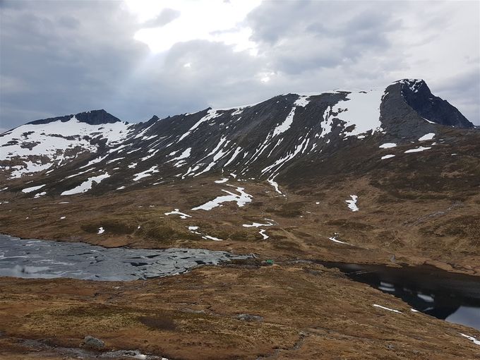 Bildet tatt på vei opp til Breidfjellet, men omtrent midt i bildet ser en demningen (hus med grønt tak) hvor en må passere vannet. I bakgrunnen til høyre er Bergehornet