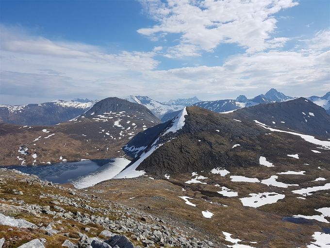 På vei opp mot med tsikt ned mot skaret en går opp med Risaskarvatnet og Hestefjellet nærmest. Midt i bakgrunn er Levandehornet
