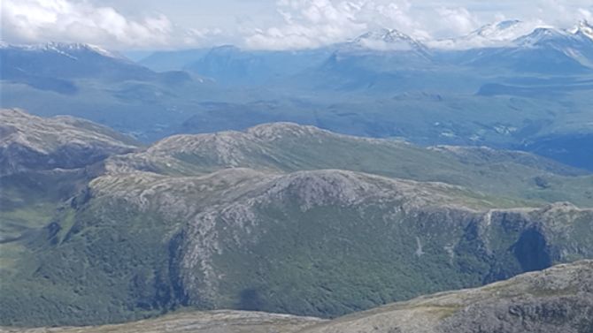 Utsikt nedover igjen med Barbrotua midt i bildet. I bakgrunn ryggen på andre siden av dalen med Sjurlihornet og Fausateighornet. Stordal i bakgrunnen til høyre.