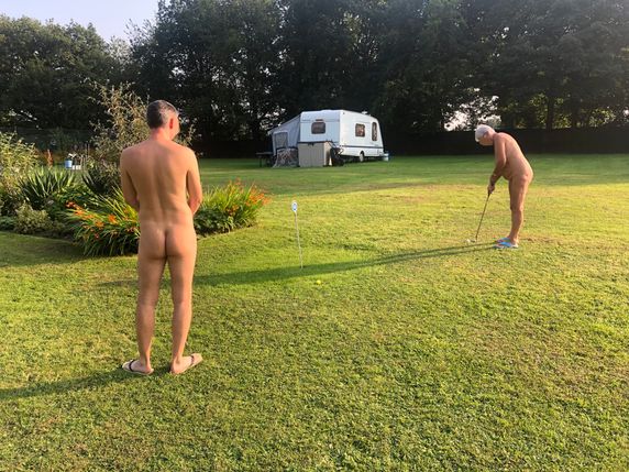 A man and a woman playing golf without clothes