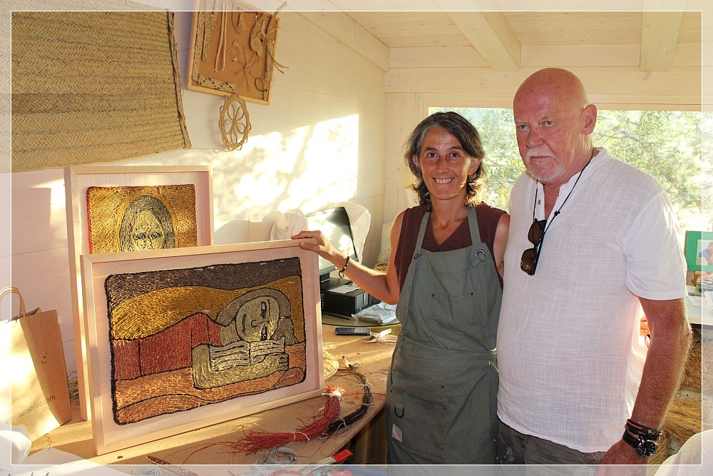La artista Ronte Alonso muestra al escritor Bernd Koldewey sus exposiciones.
