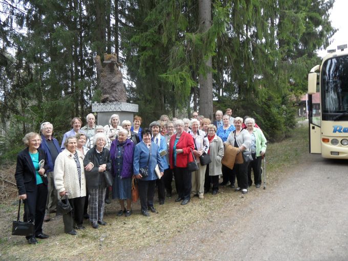 Myllypuron Eläkeläiset yhteiskuvassa ateljeen betonikarhu veistoksen edustalla. 450 kiloa painava ja 3 m. korkea pihaveistos toivottaa vieraat tervetulleiksi Villa Vesperiin.