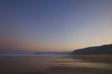 MC 19 065 - Sunset - a-beach-with-a-few-waves-and-a-plane-flying-in-th
