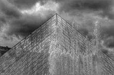 MC 19 076 - The Louvre in dark skies - a-black-and-white-photo-of-a-fo