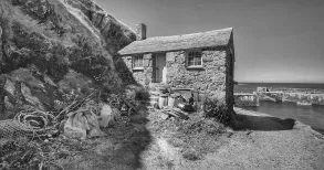 MC 20 119 - a-black-and-white-photo-of-a-house-on-the-shore