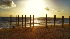 MC 20 123 - Old Brighton Pier - a-beach-with-a-fence-and-the-sun-shini
