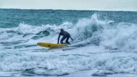 MC 21 143 - surfer - a-man-in-a-wet-suit-surfing-on-a-yellow-surfboard