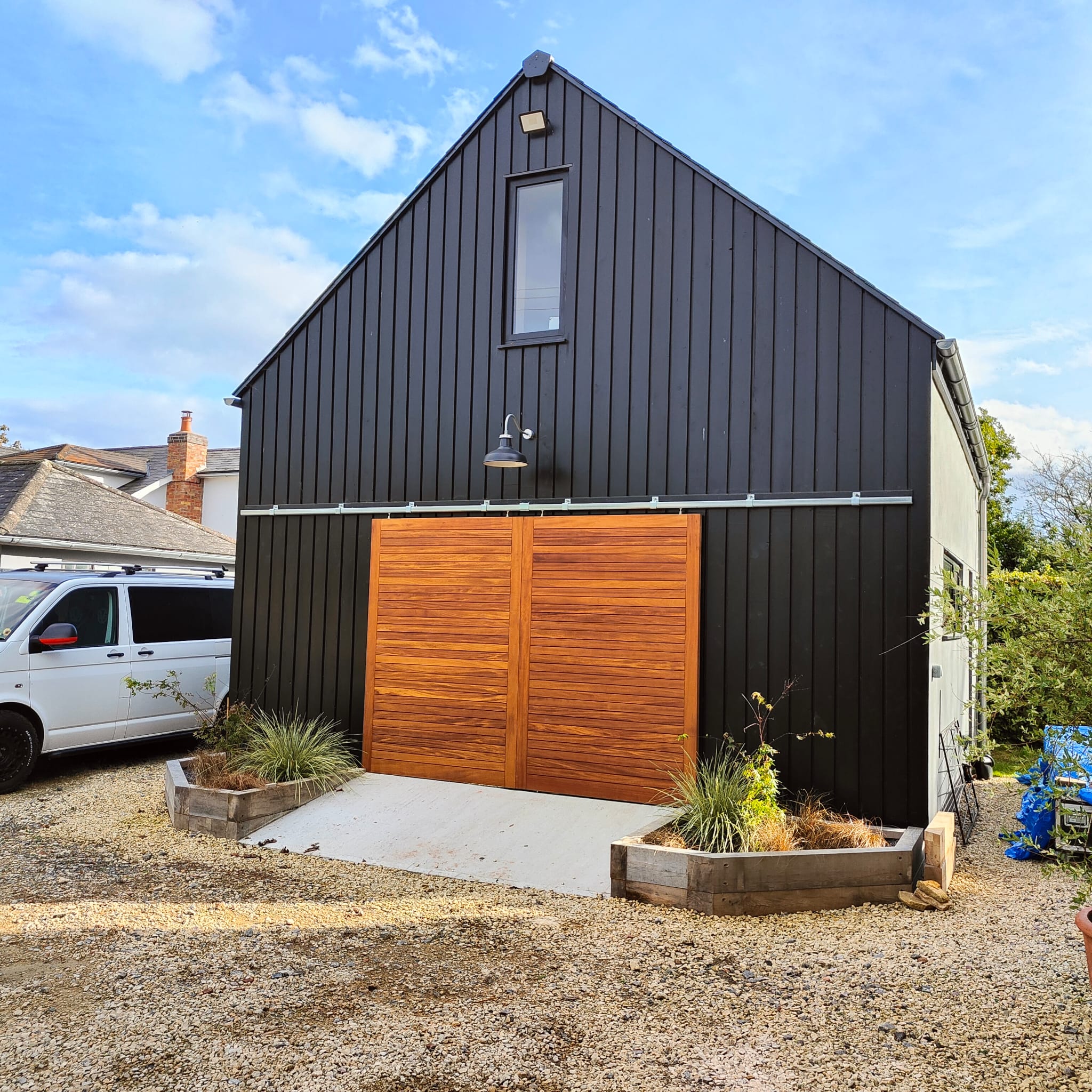 Two-storey garage with larch cladding and cedar barn doors on tracks